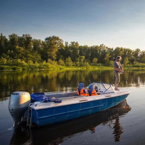 Man fishing off a boat at sunset on a lake